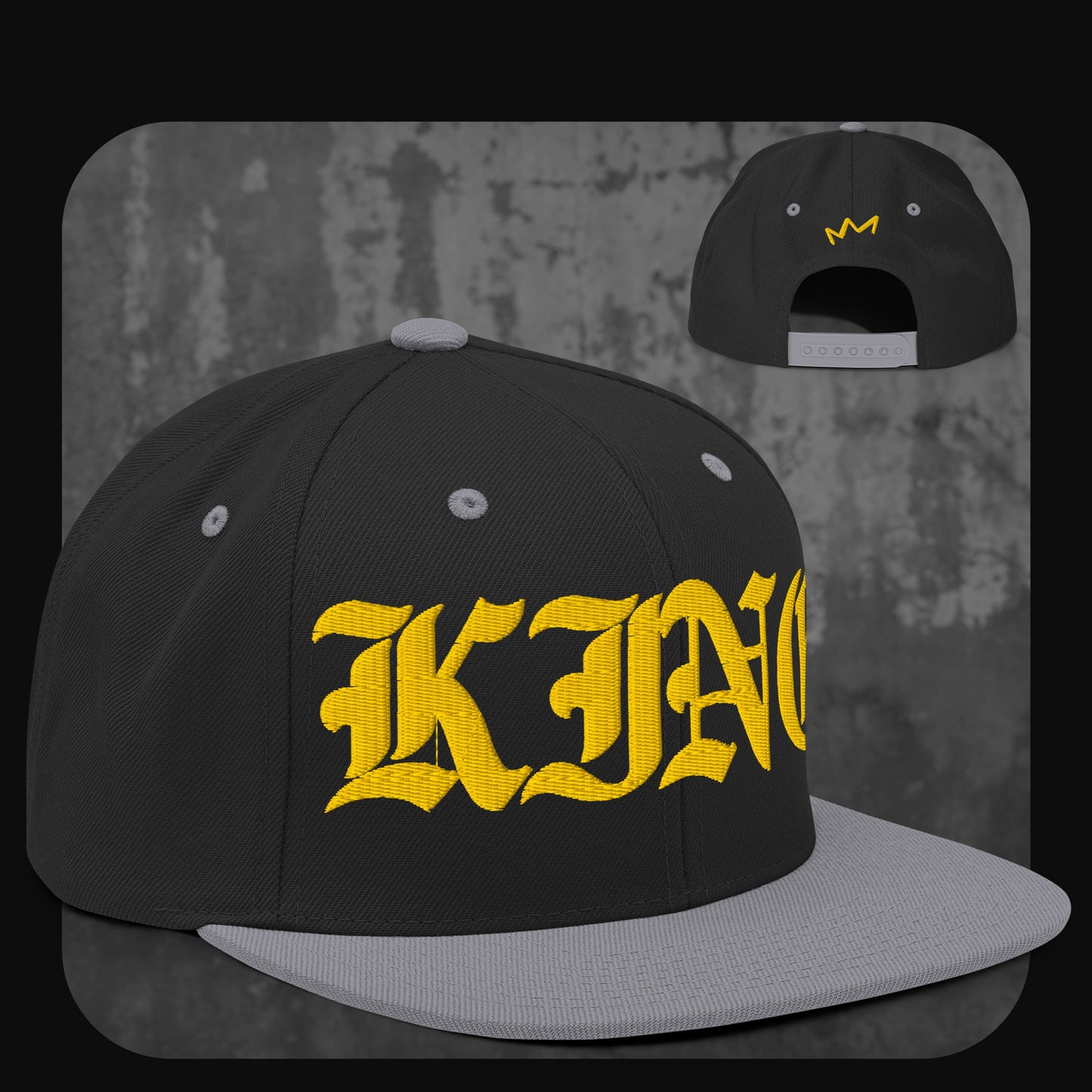 Schwarze Snapback-Cap mit grauer Krempe, grauen Ösen und grauem Knopf. Auf der Vorderseite gelber „KING“-Schriftzug, auf der Rückseite kleine gelbe Krone.