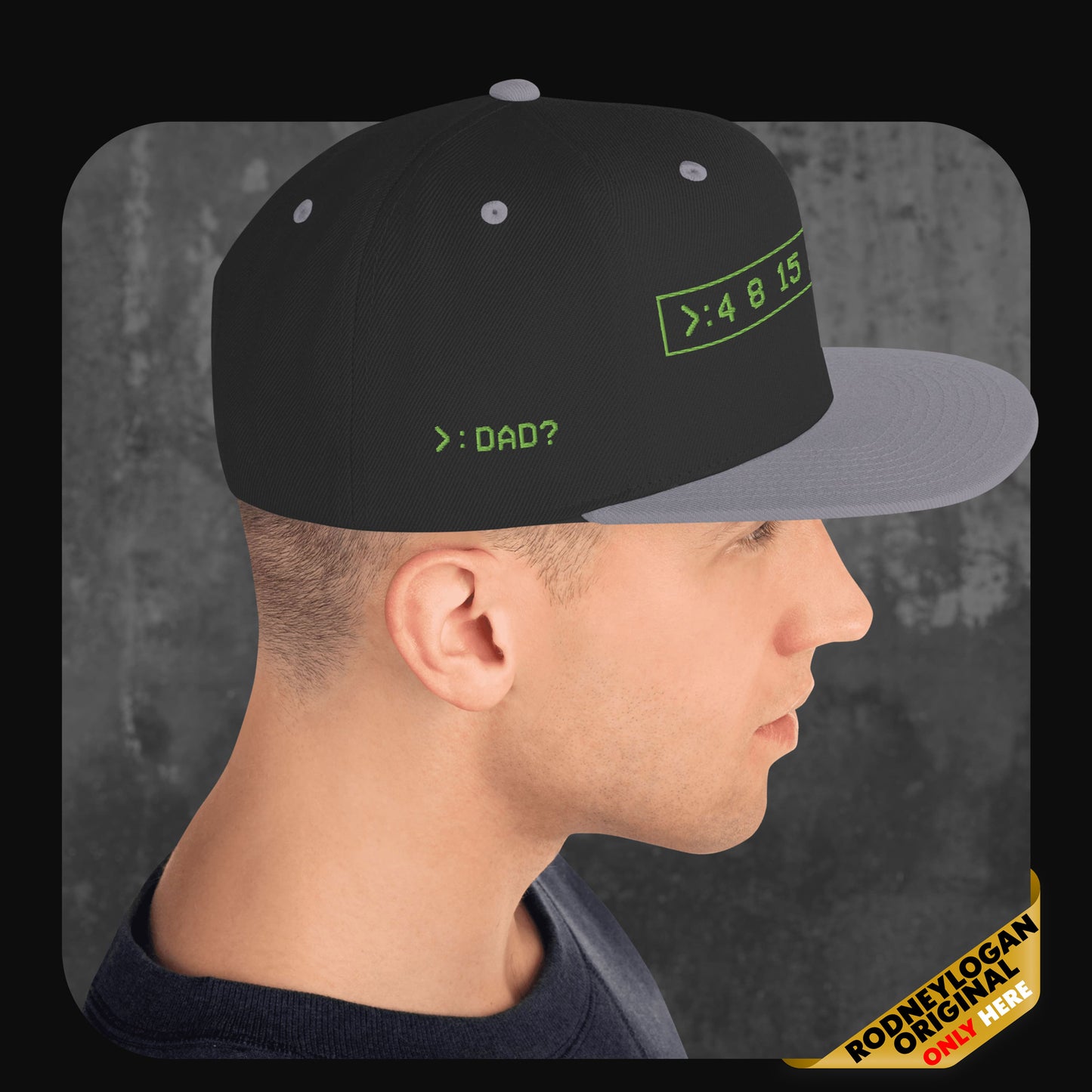 Mann trägt eine schwarze Snapback-Cap mit grauer Krempe und grauen Ösen. Vorne leuchtend grüner Digital-Schriftzug „>: 4 8 15“ im Rechteck, seitlich der Text „>: DAD?“.