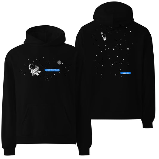 An oversized black hoodie featuring a minimalist design of a small white spaceman graphic floating in space, accompanied by subtle white text. A sleek and cosmic-inspired piece for fans of space exploration and modern aesthetics.