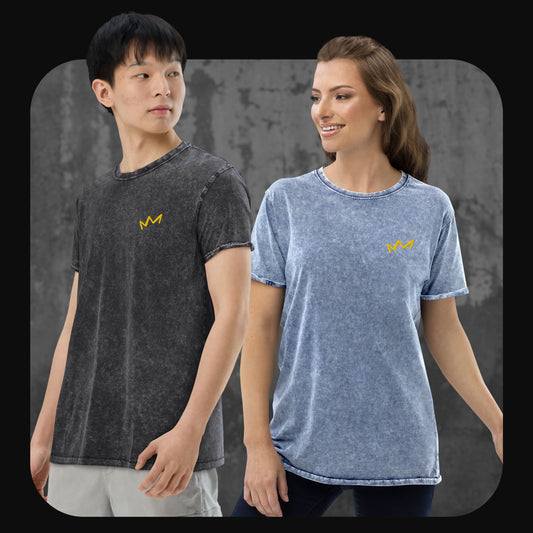 Mann in schwarzem Acid-Wash-T-Shirt und Frau in blauem Acid-Wash-T-Shirt, beide mit gelber Krone links auf der Brust. Hintergrund in grauer Betonoptik.