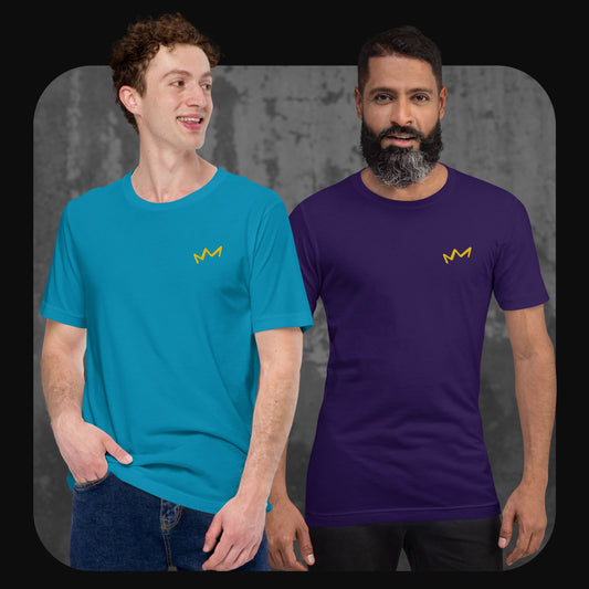 Zwei Männer tragen T-Shirts mit gelber Krone auf der linken Brust, einer in Türkis, der andere in Lila. Hintergrund in Betonoptik.
