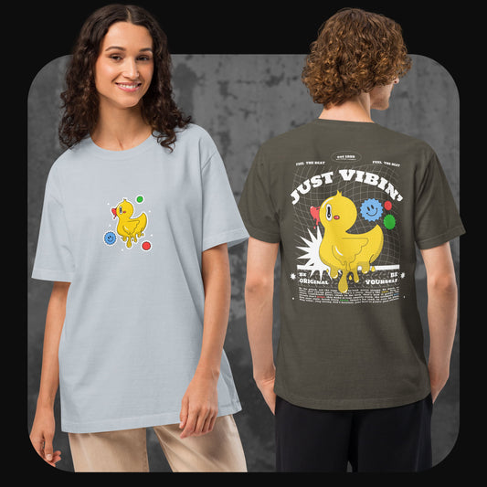 Eine Frau trägt ein hellgraues T-Shirt mit kleiner Frontgrafik einer gelben Cartoon-Ente, daneben ein Mann mit olivgrünem Shirt, Rückendruck „JUST VIBIN’“ und großer Entengrafik.