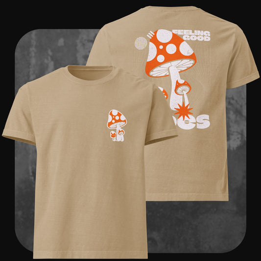 Beiges T-Shirt mit kleinem roten Fliegenpilz vorne links auf der Brust. Rückseite zeigt einen großen Fliegenpilz mit Schriftzug „Feeling Good Vibes“ in Weiß.
