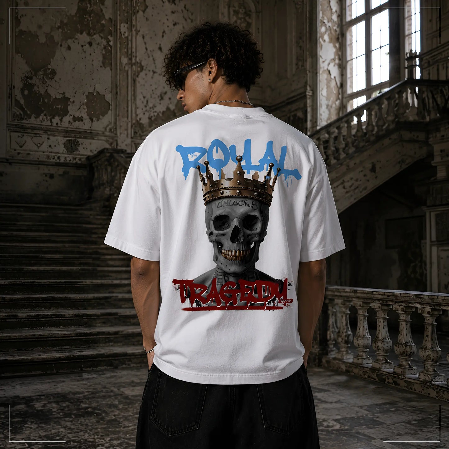 Rückansicht des Rodney Logan ROYAL TRAGEDY weißen Oversized T-Shirts mit großem gekröntem Totenkopf und Graffiti-Schriftzug in Blau und Rot.