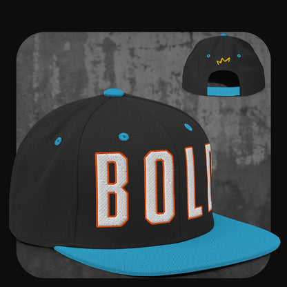 Schwarze Snapback-Cap mit blauer Krempe, blauen Ösen und blauem Knopf. Vorne steht das Wort „BOLD“ in großen weißen Blockbuchstaben mit orangefarbener Umrandung, hinten kleines gelbes Kronenlogo.