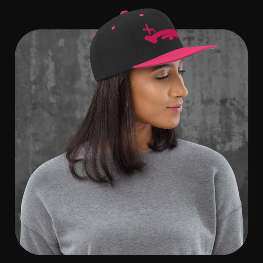 Modell trägt die Rodney Logan Snapback Cap „Broken Heart“ mit schwarzer Krone und pinkem Schirm in seitlicher Ansicht.
