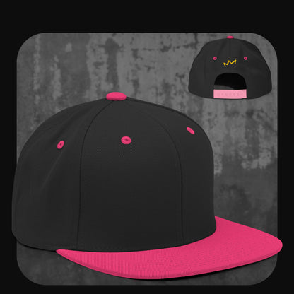 Schwarze Snapback-Cap mit pinkem Schirm, Knopf, Stickösen und pinkem Verschluss – gelbe Krone auf der Rückseite.
