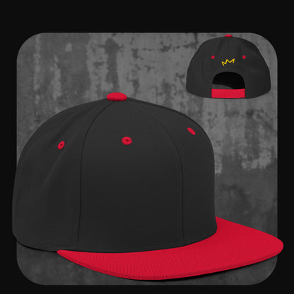 Schwarze Snapback-Cap mit rotem Schirm, Knopf, Stickösen und Verschluss – gelbe Krone auf der Rückseite.

