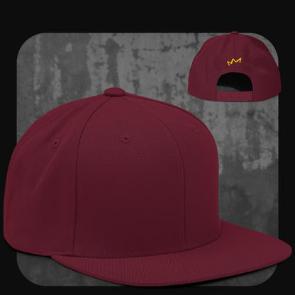 Snapback-Cap in Bordeauxrot mit Ton-in-Ton-Design und gelbem Krönchen-Logo auf der Rückseite.