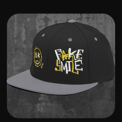 RodneyLogan Snapback Cap von vorne-links mit gelber Smiley-Stickerei und Fake Smile Schriftzug.