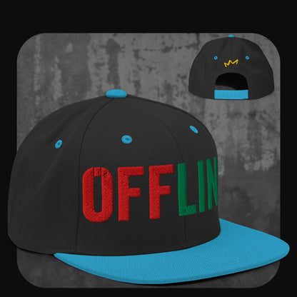 Schwarze Snapback-Cap mit blauer Krempe, blauen Ösen und blauem Knopf. Auf der Vorderseite steht „OFFLINE“ in großen Blockbuchstaben, wobei „OFF“ in Rot und „LINE“ in Grün gestickt ist, hinten kleine gelbe Krone.