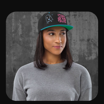 Model trägt die Stay Alive Snapback Cap mit passendem Streetwear-Outfit